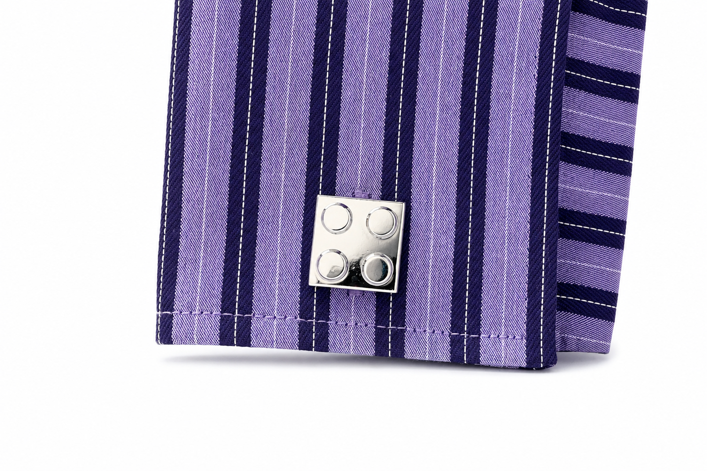 Close-up of a purple striped fabric with a silver button on a white background