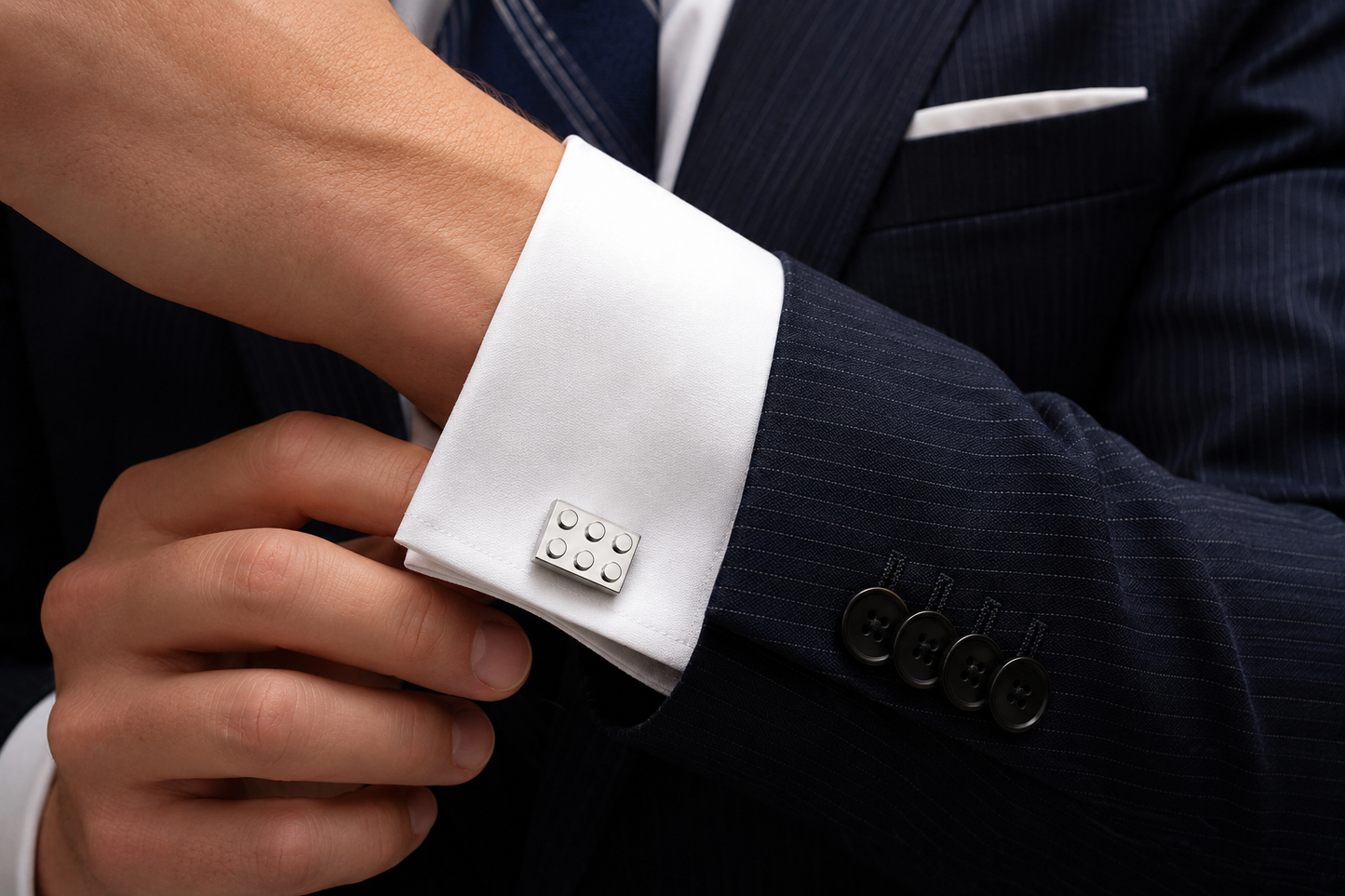 Silver building block cufflinks worn with white French cuff shirt and navy business suit
