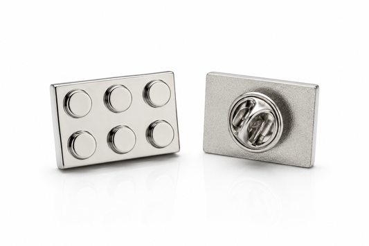 Silver building block lapel pin with six raised studs and butterfly clutch backing on white background
