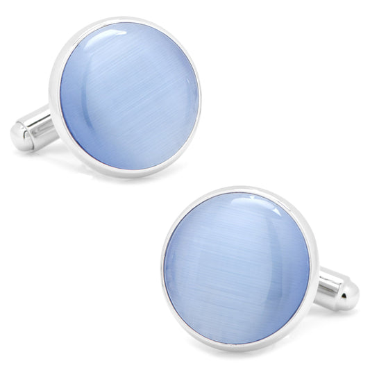 Pair of light blue round cufflinks with silver borders on a white background