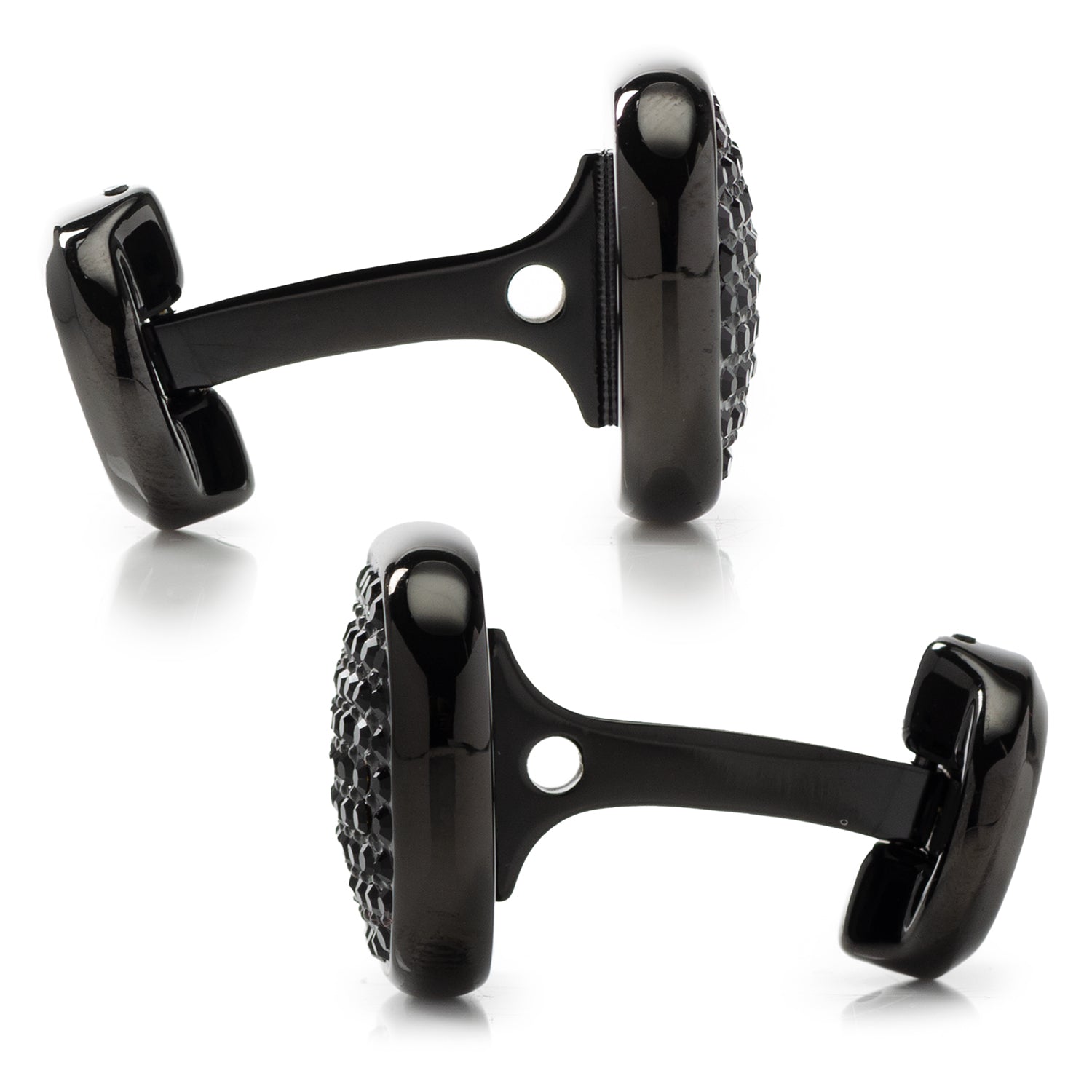 Black cufflinks with detailed design on a white background