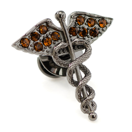 Metallic brooch with leaf design and brown gemstones on a white background
