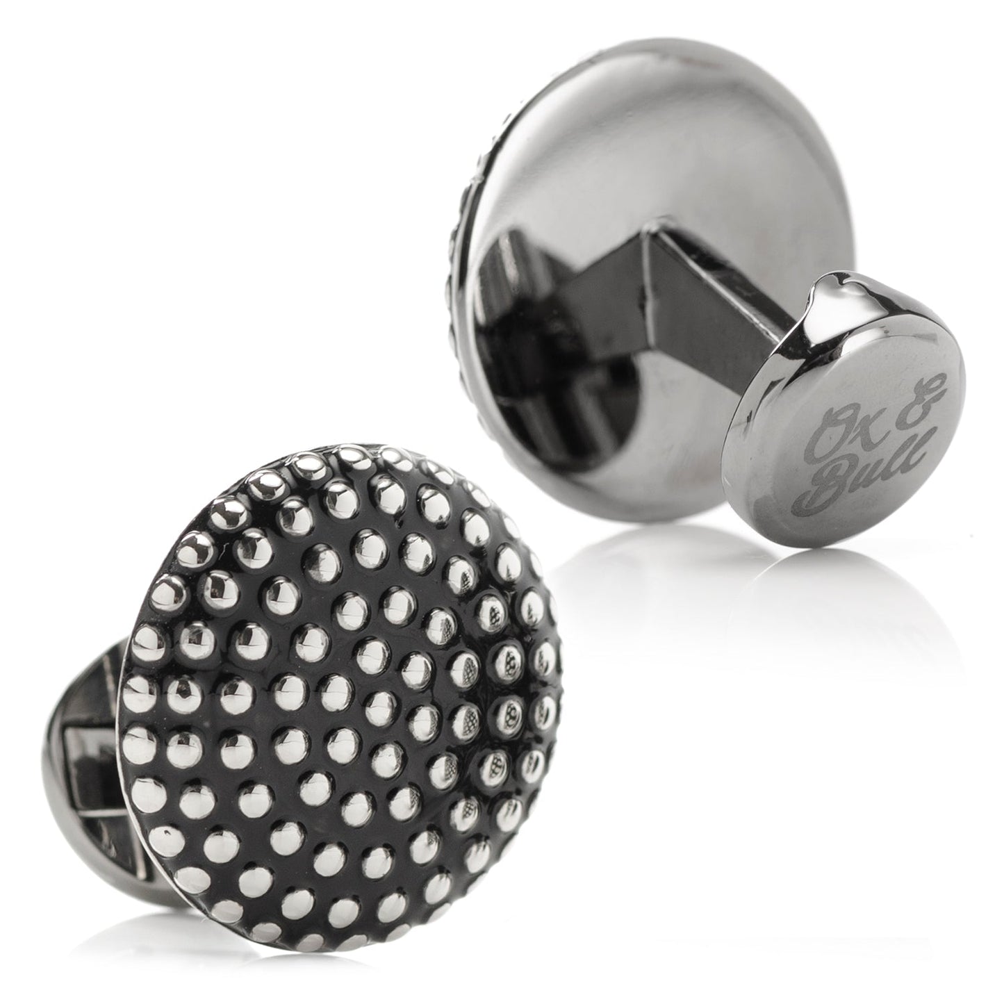 Cufflinks with black and silver polka dot design on a white background