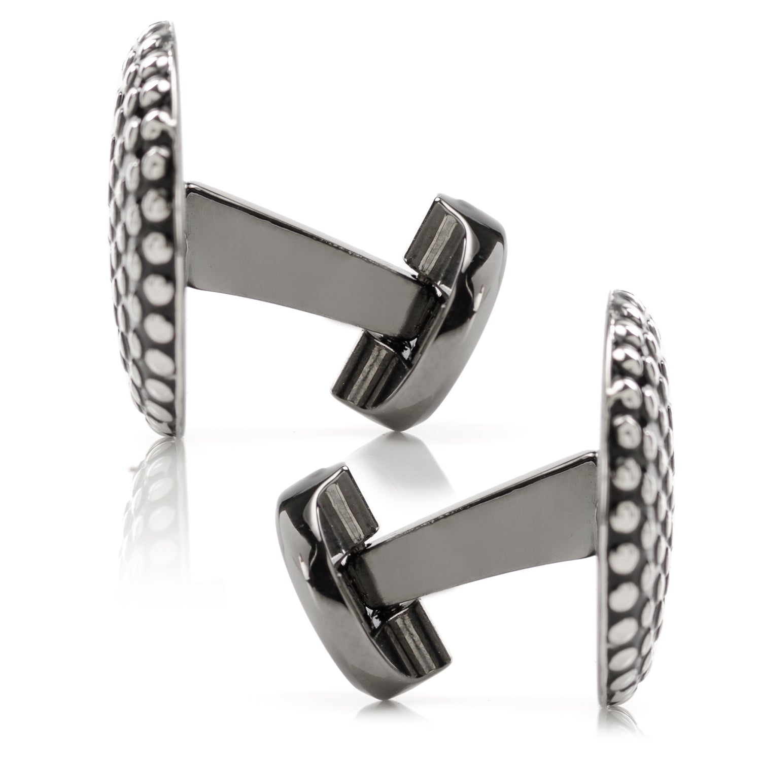 Pair of silver cufflinks with intricate design on a white background