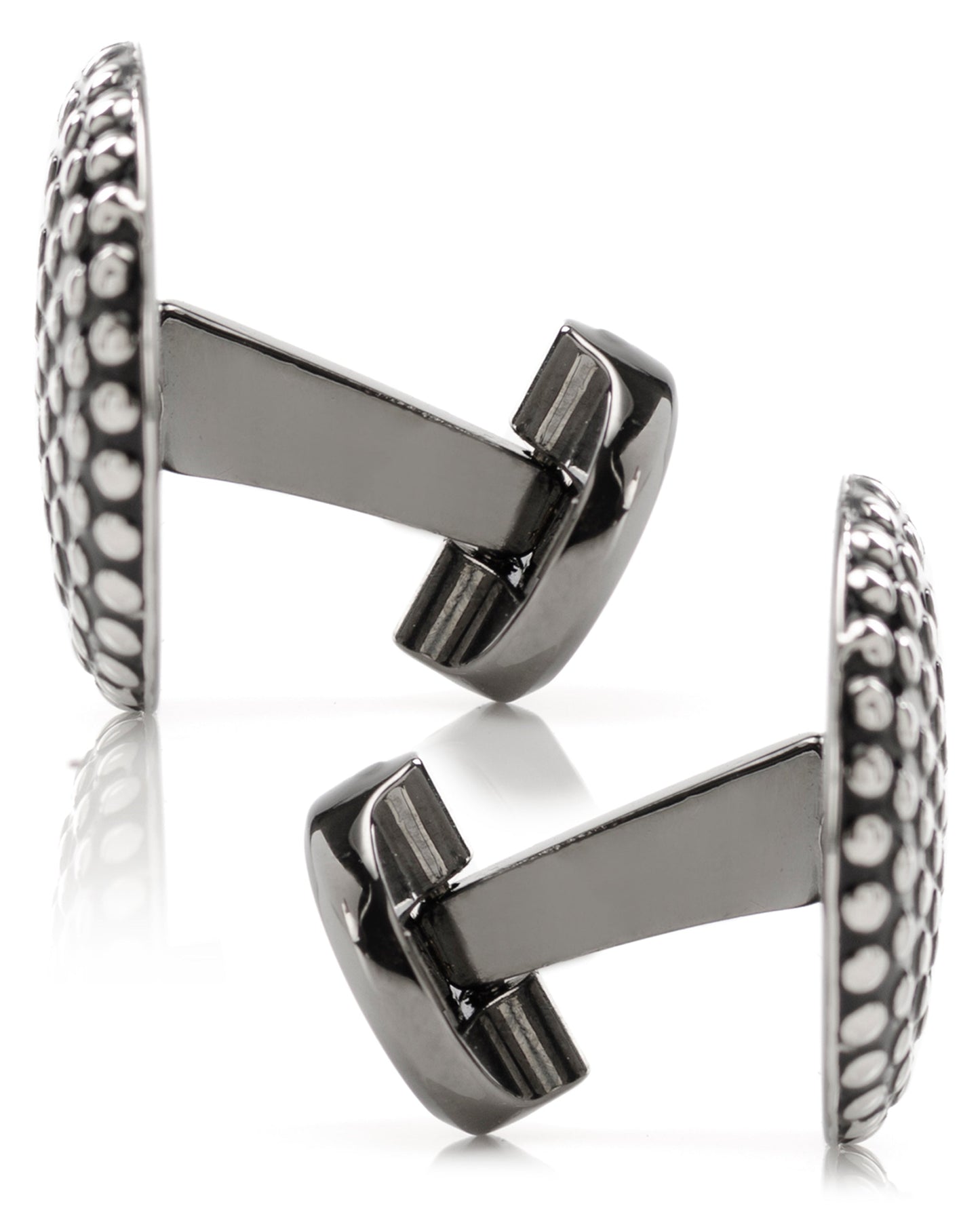 Pair of silver cufflinks with intricate design on a white background