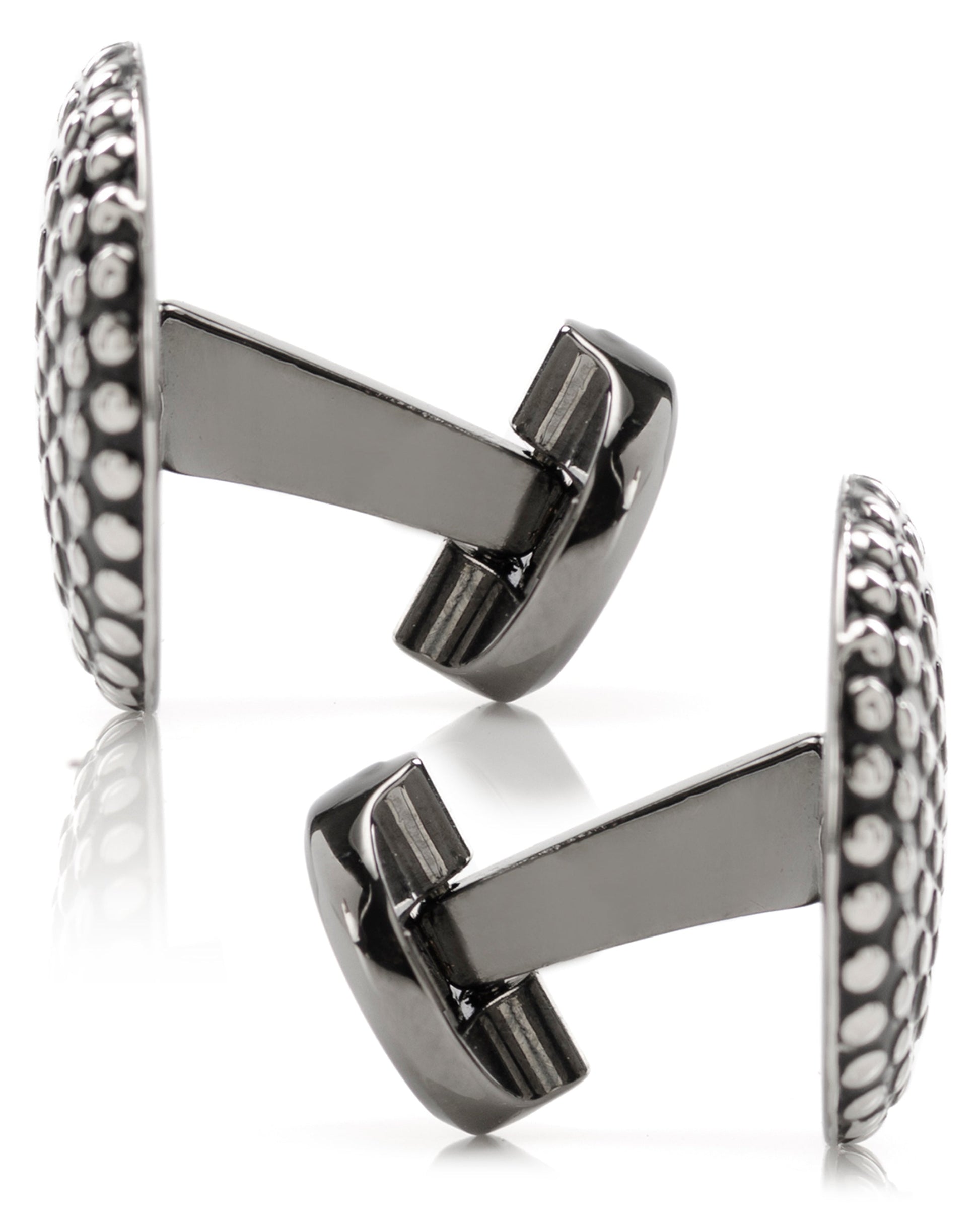 Pair of silver cufflinks with intricate design on a white background