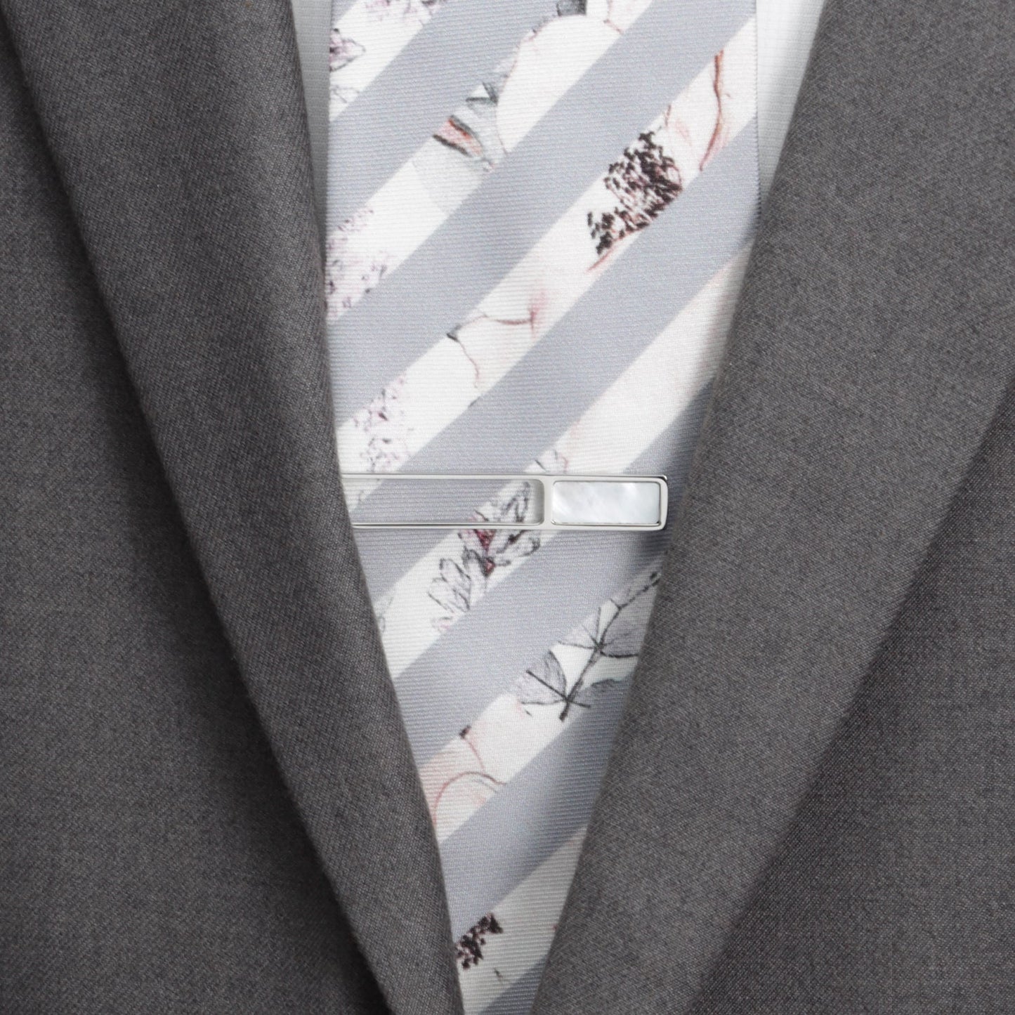 Close-up of a gray suit with a floral-patterned tie