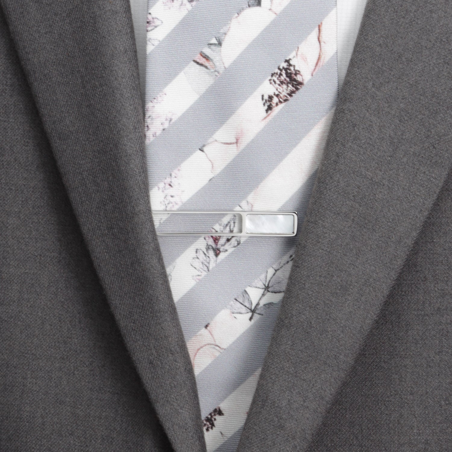 Close-up of a gray suit with a floral-patterned tie