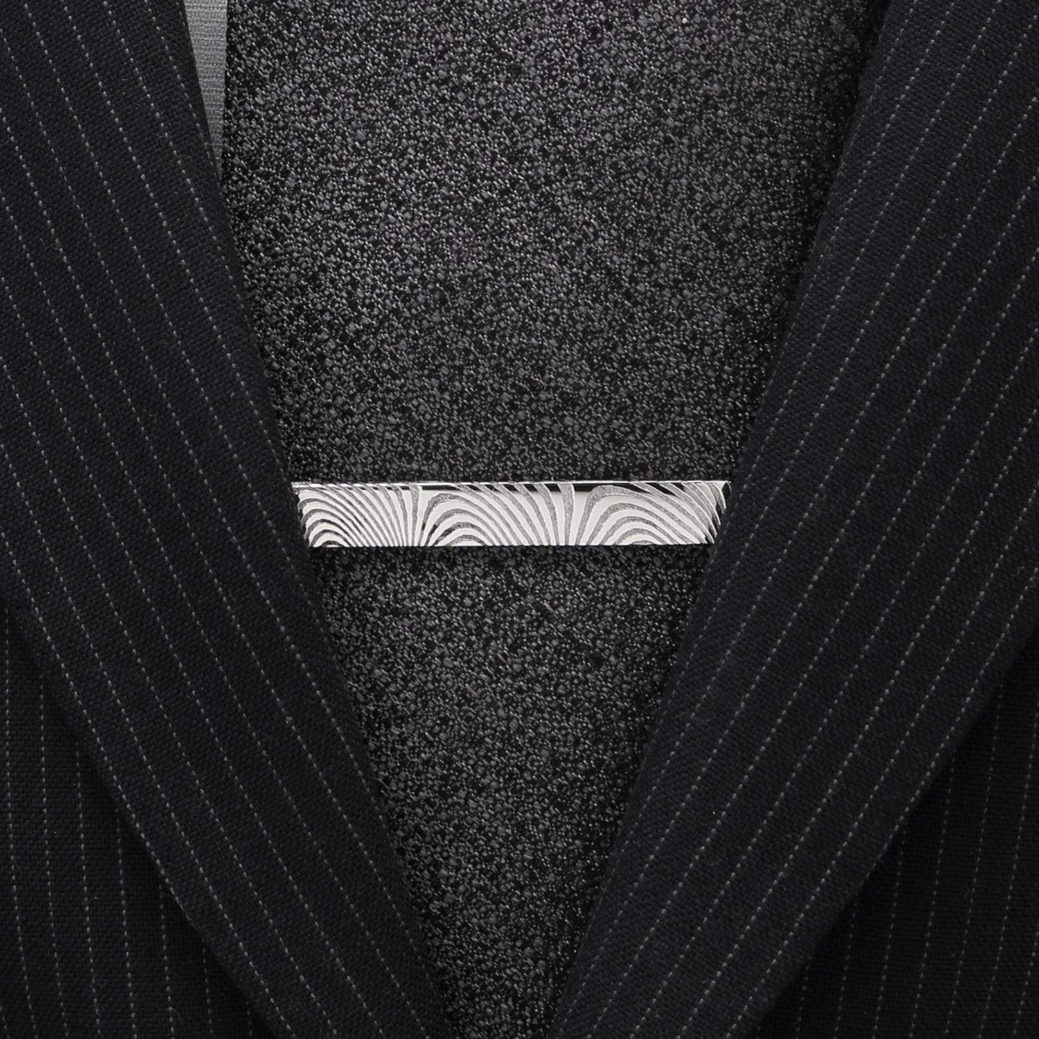 Close-up of a textured pocket square with a zebra pattern in a black pinstripe suit.
