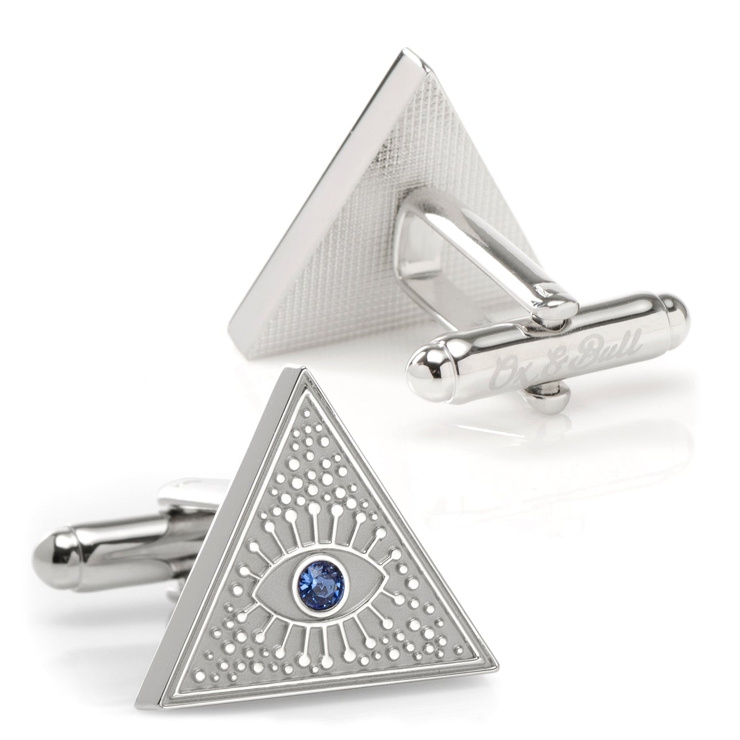 Triangular cufflinks with eye design and blue gemstone on a white background