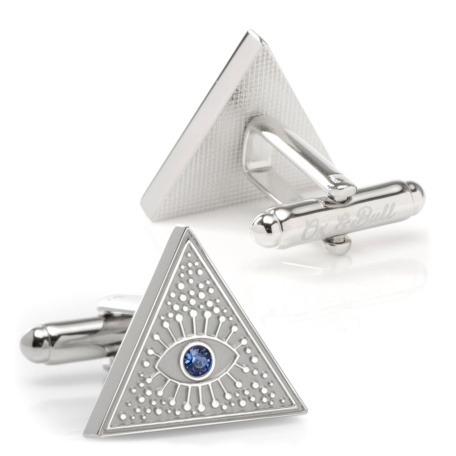 Triangular cufflinks with eye design and blue gemstone on a white background