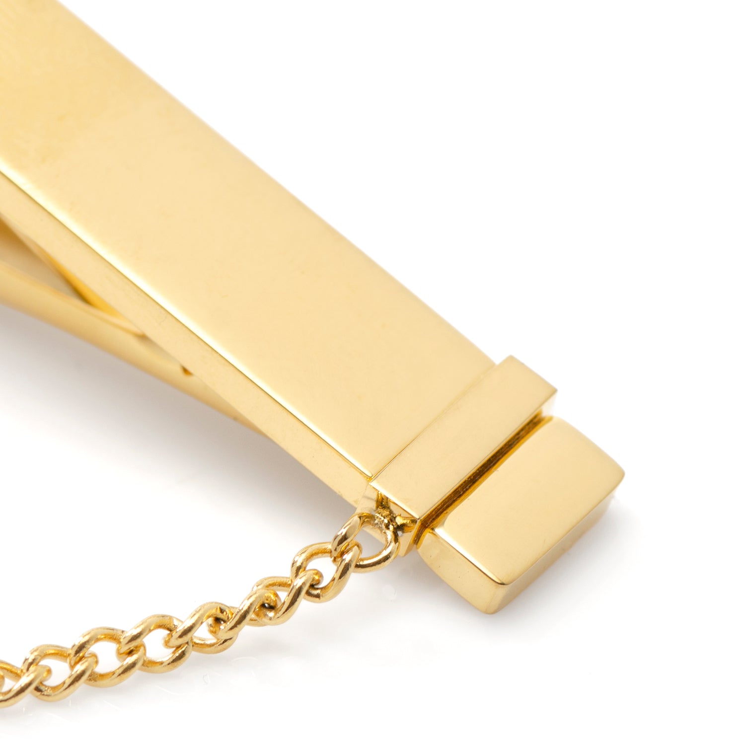 Gold tie clip with chain on a white background