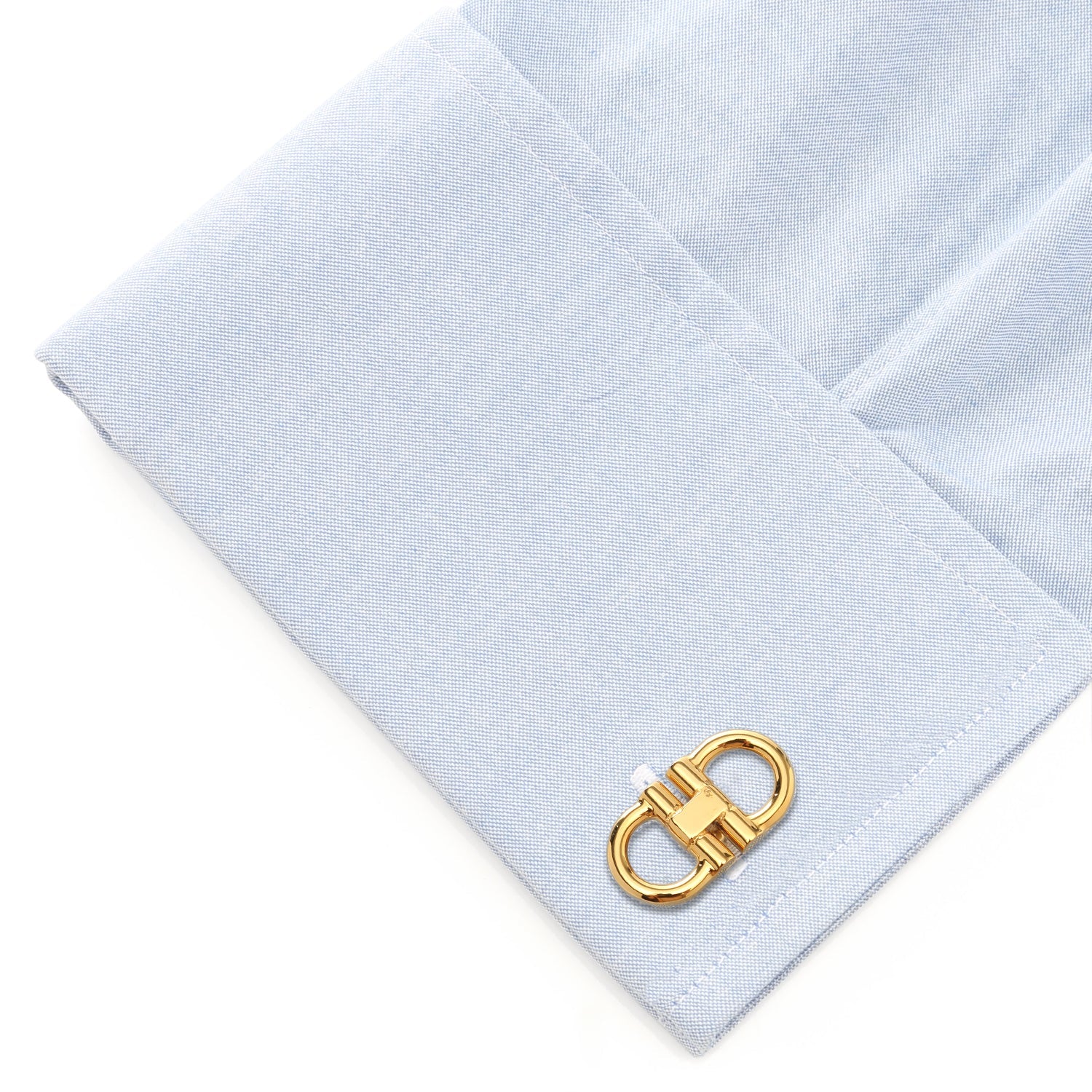 Gold cufflink on a light blue dress shirt