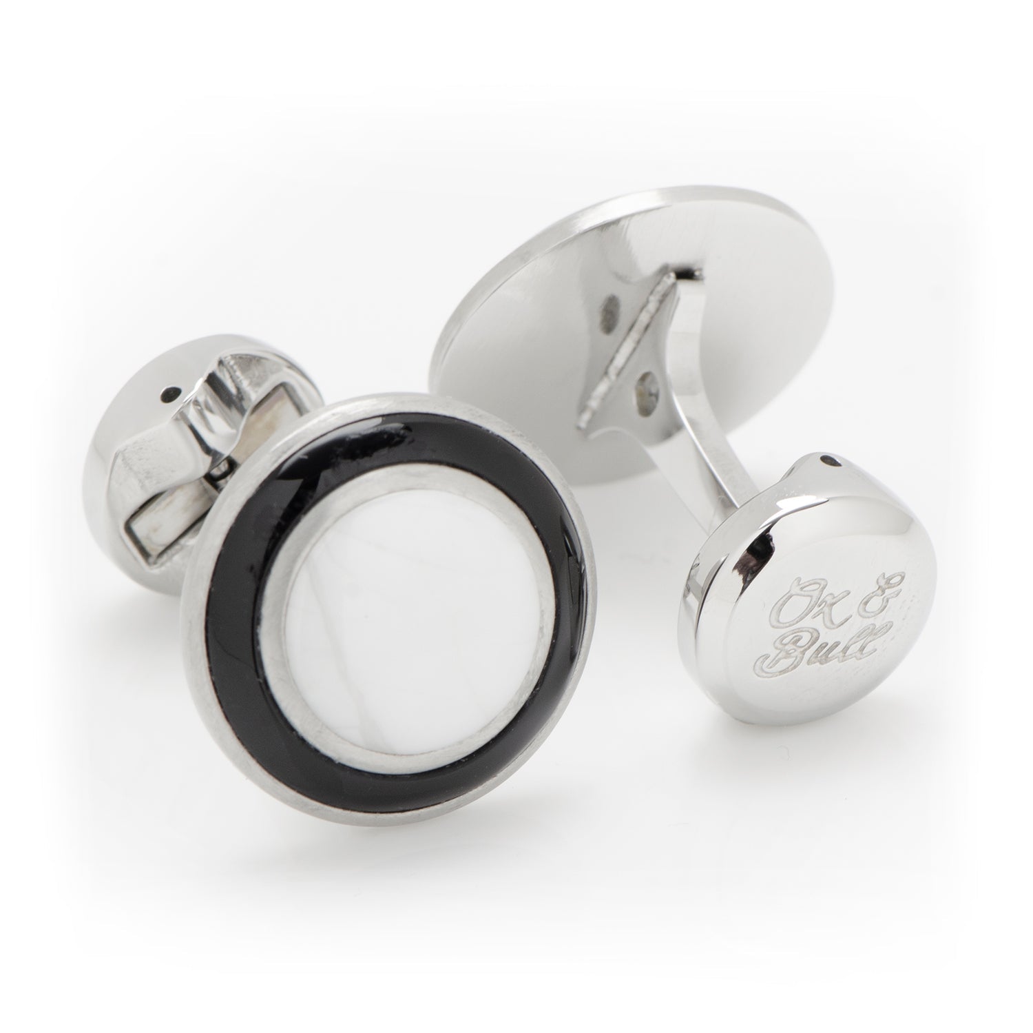 Silver cufflinks with a black and white circular design on a white background