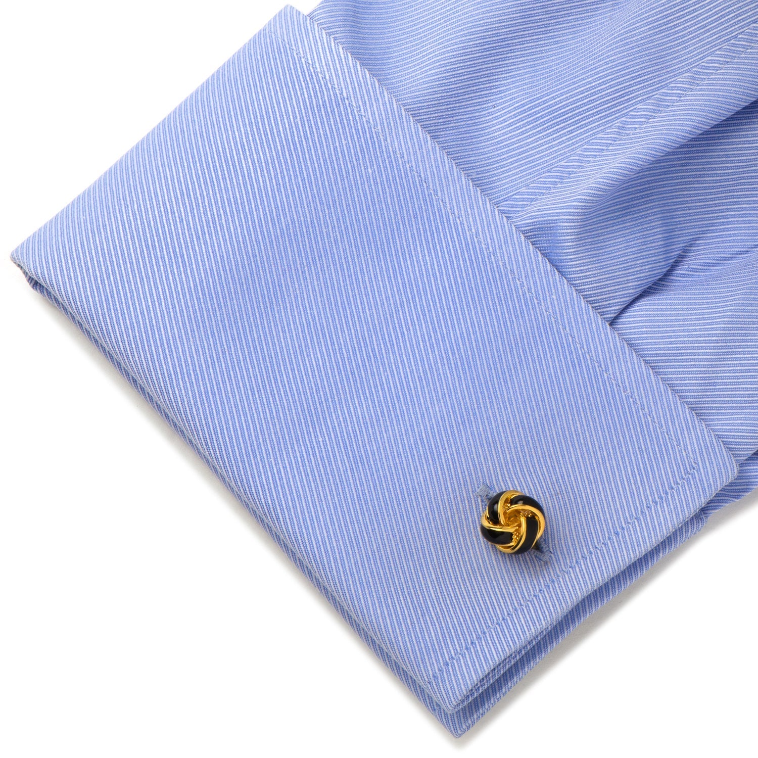 Close-up of a blue striped shirt cuff with a decorative cufflink.