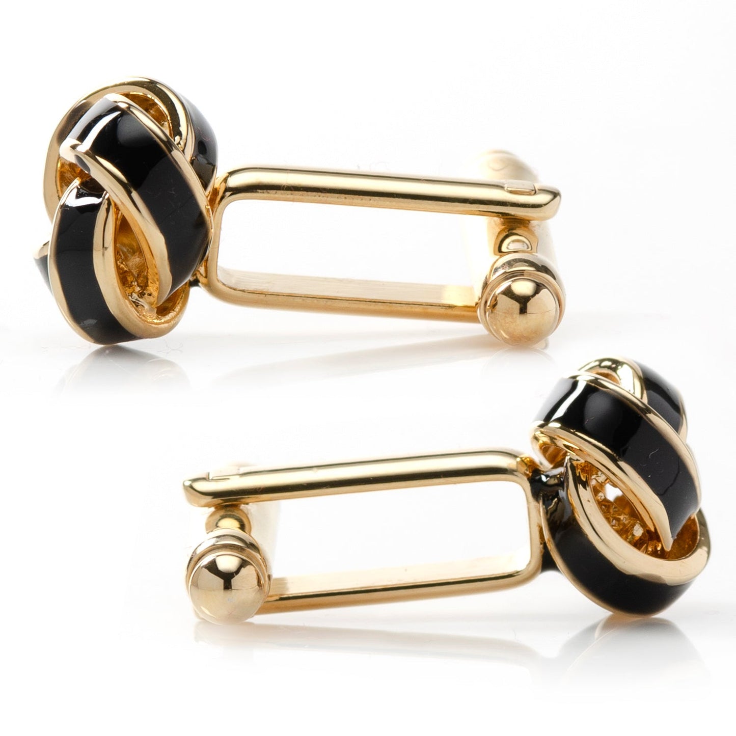 Gold and black cufflinks on a white background