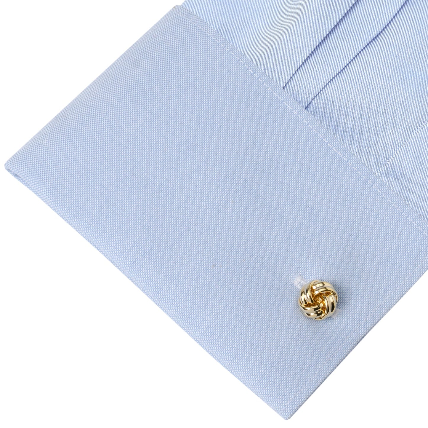Gold knot cufflinks on a light blue dress shirt