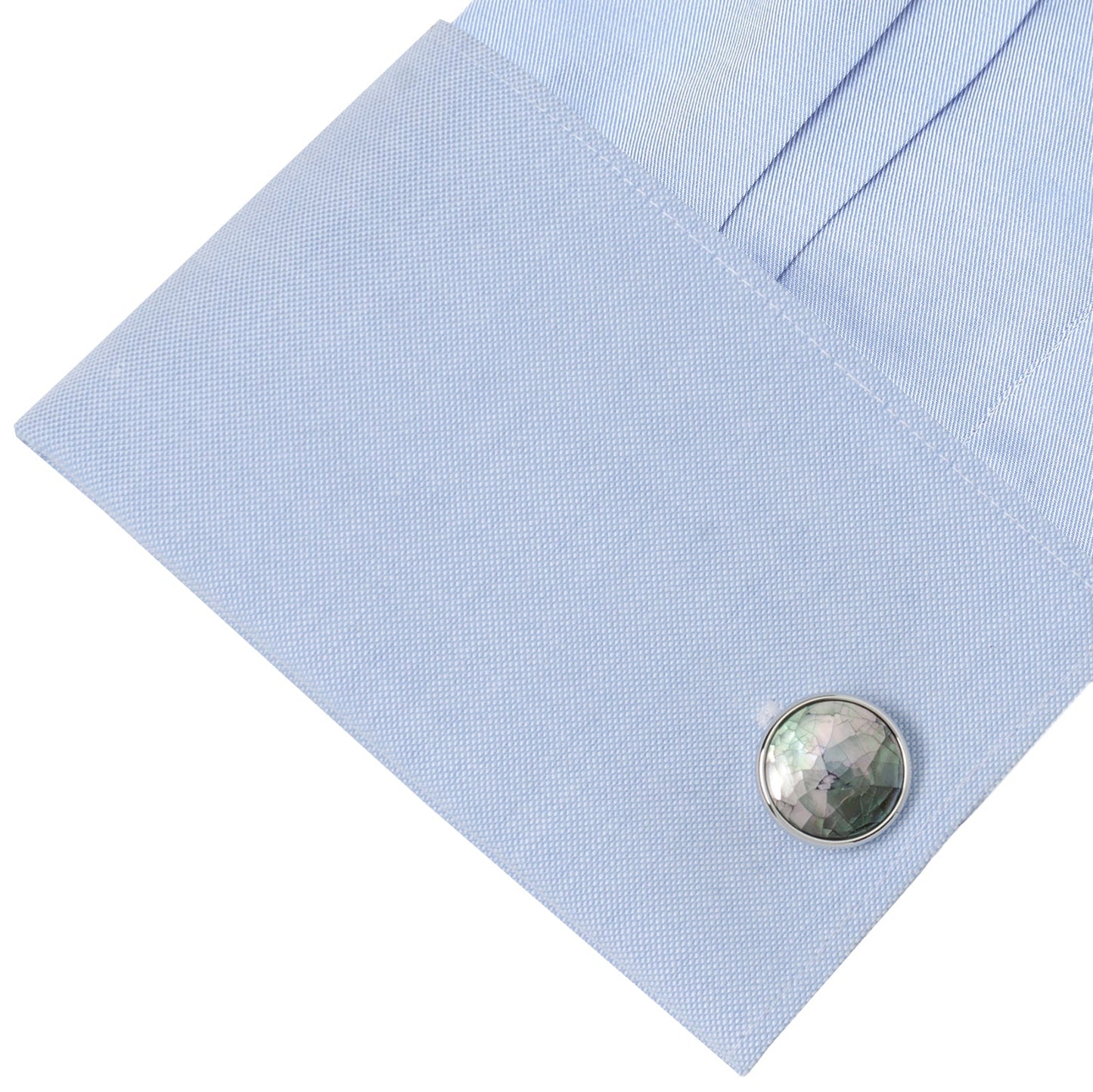 Close-up of a light blue pocket square with a round, textured cufflink on a white background