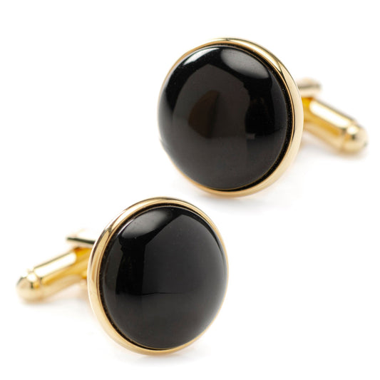 Black cufflinks with gold rims on a white background