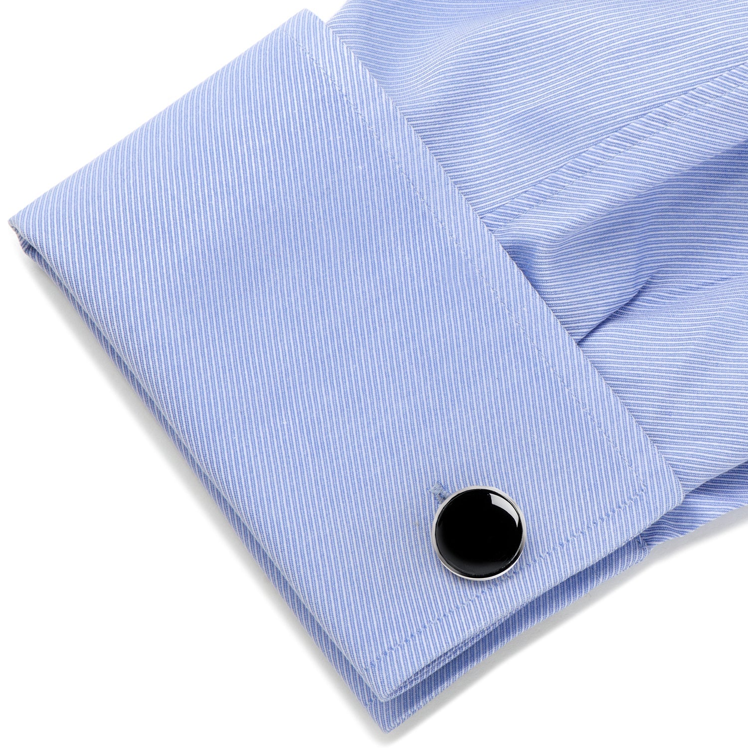 Black cufflink on a light blue striped shirt