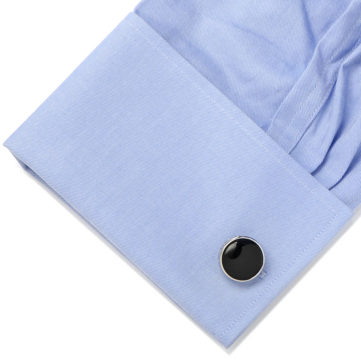 Black cufflink on a light blue shirt
