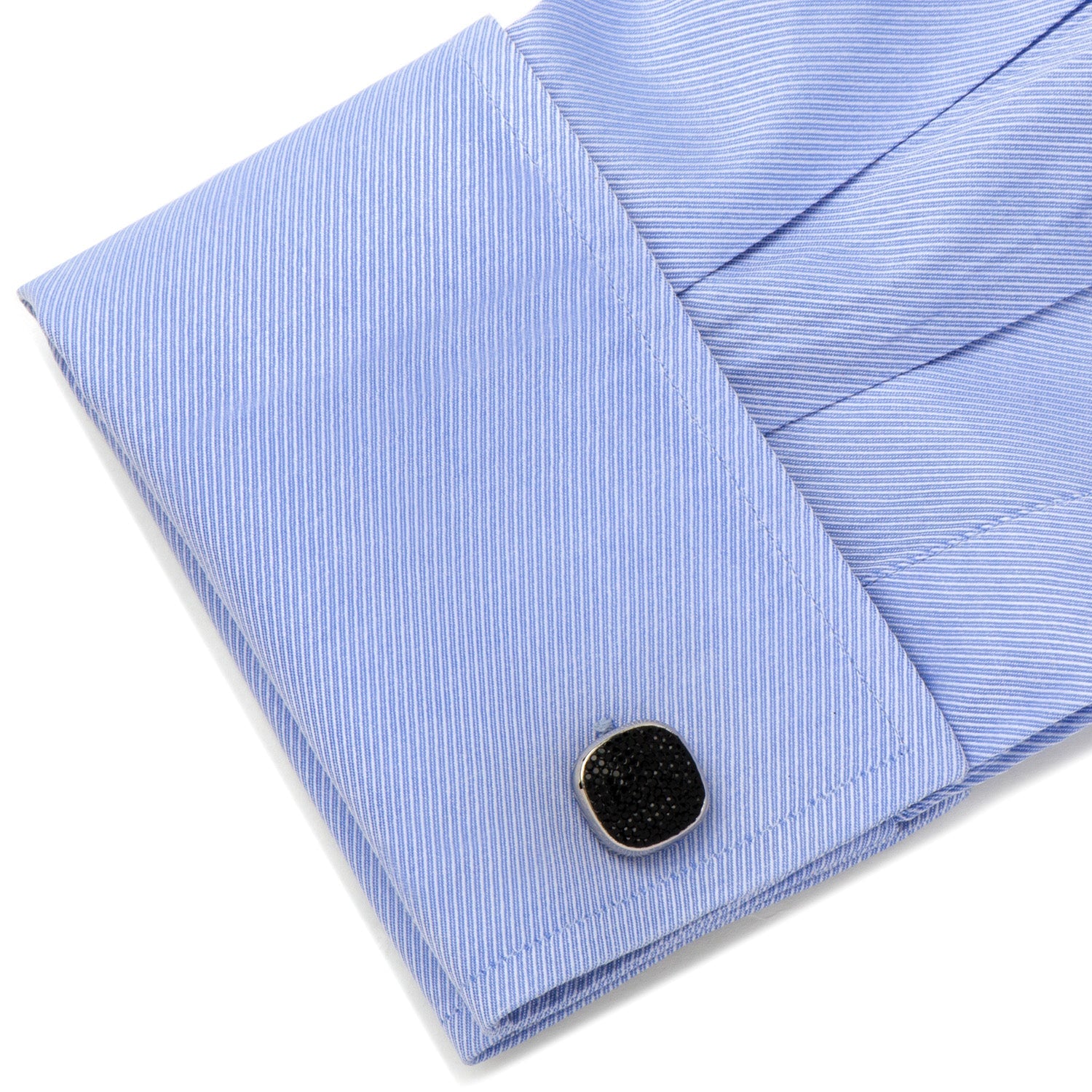 Close-up of a blue striped shirt with a cufflink on a white background