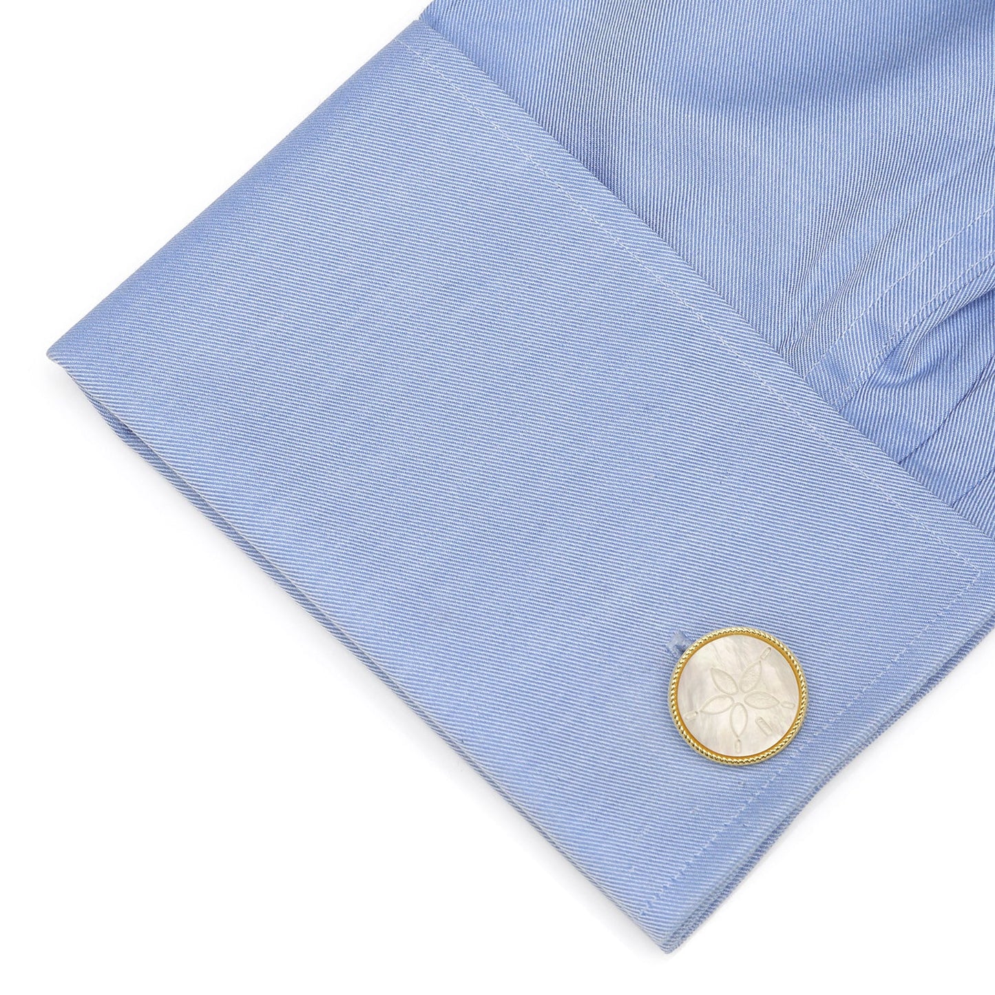 Close-up of a light blue shirt cuff with a cufflink on a white background