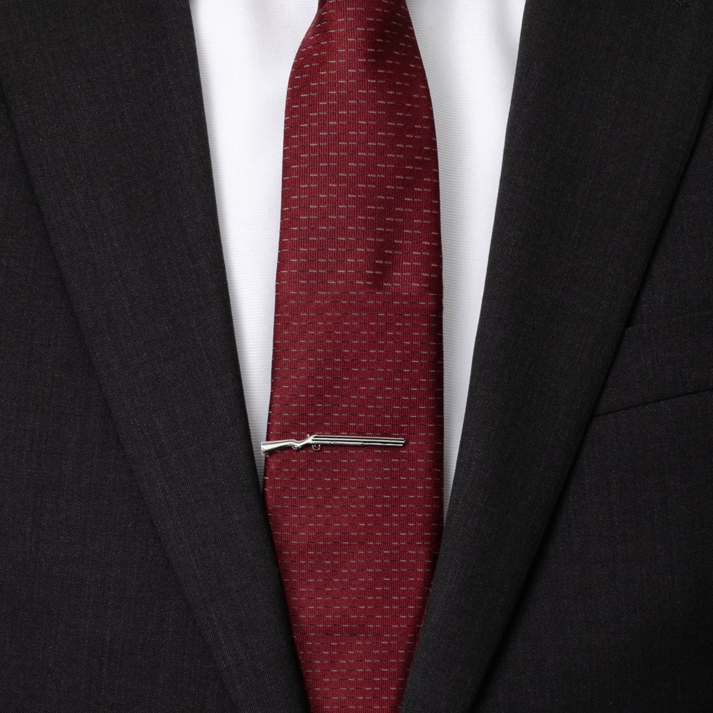 Red tie with a silver tie clip on a black suit jacket