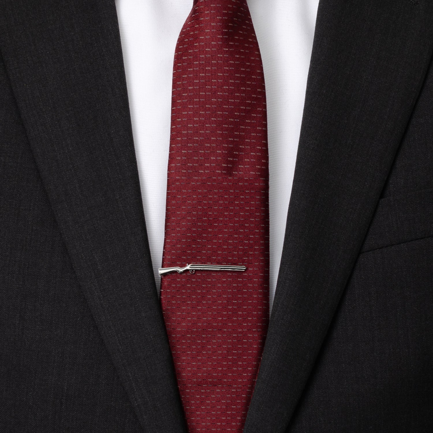 Red tie with a silver tie clip on a black suit jacket