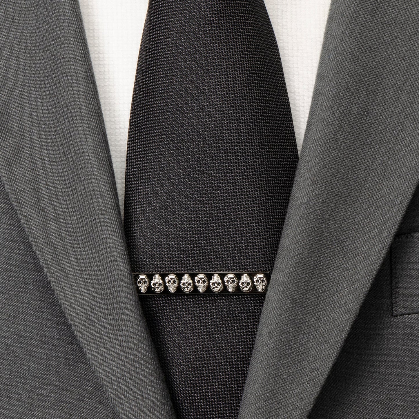 Black tie with skull design barrette on a gray suit jacket