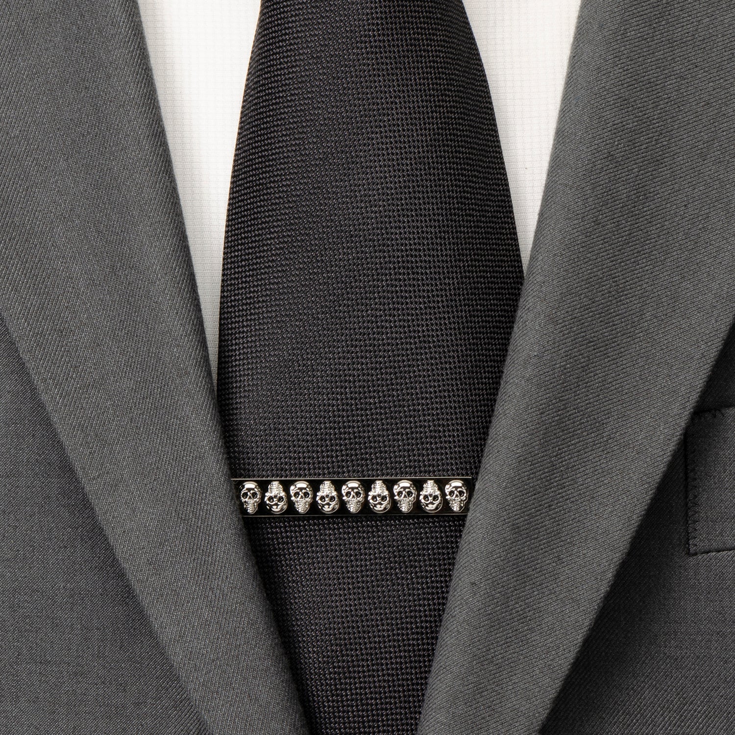 Black tie with skull design barrette on a gray suit jacket