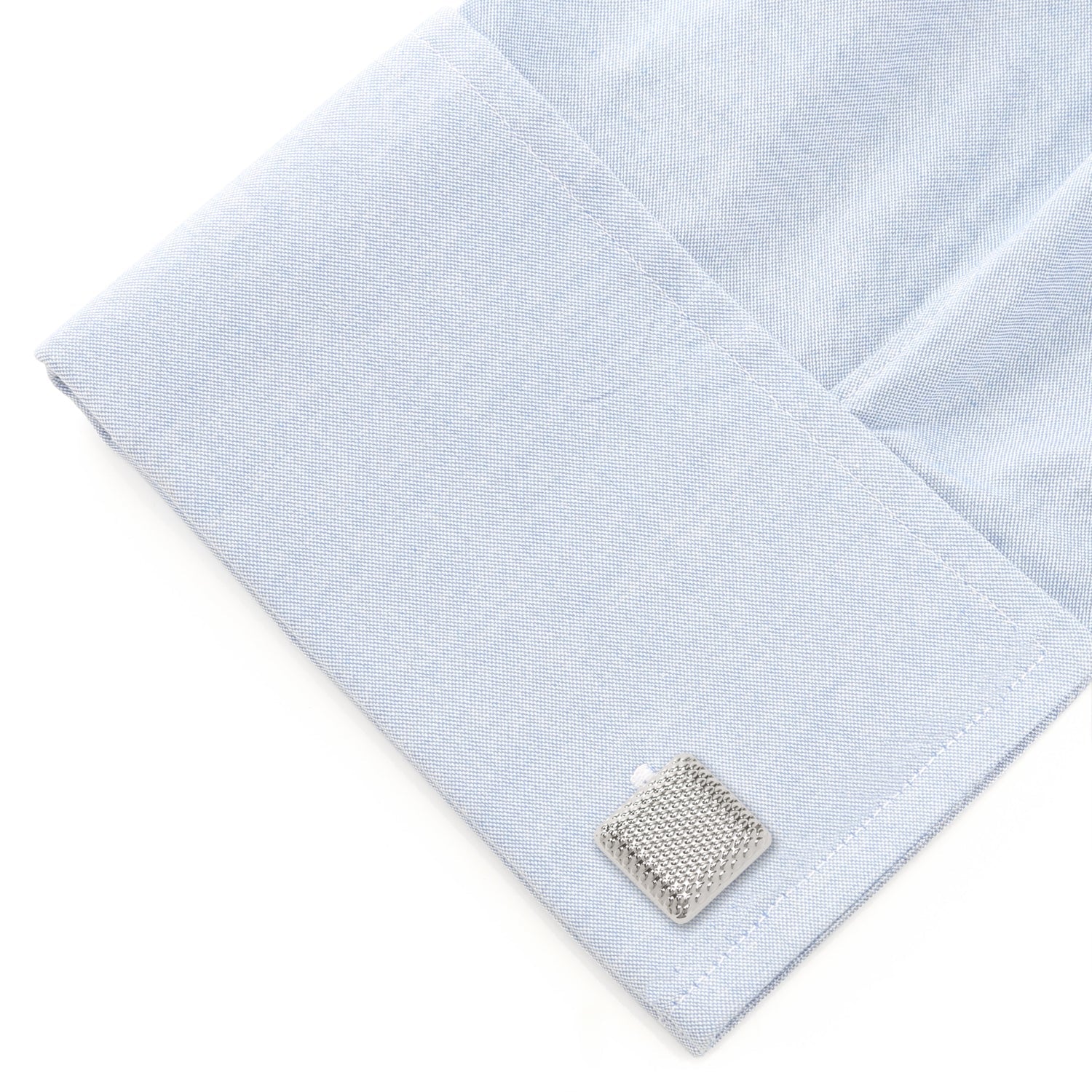 Light blue pocket square with a silver cufflink on a white background