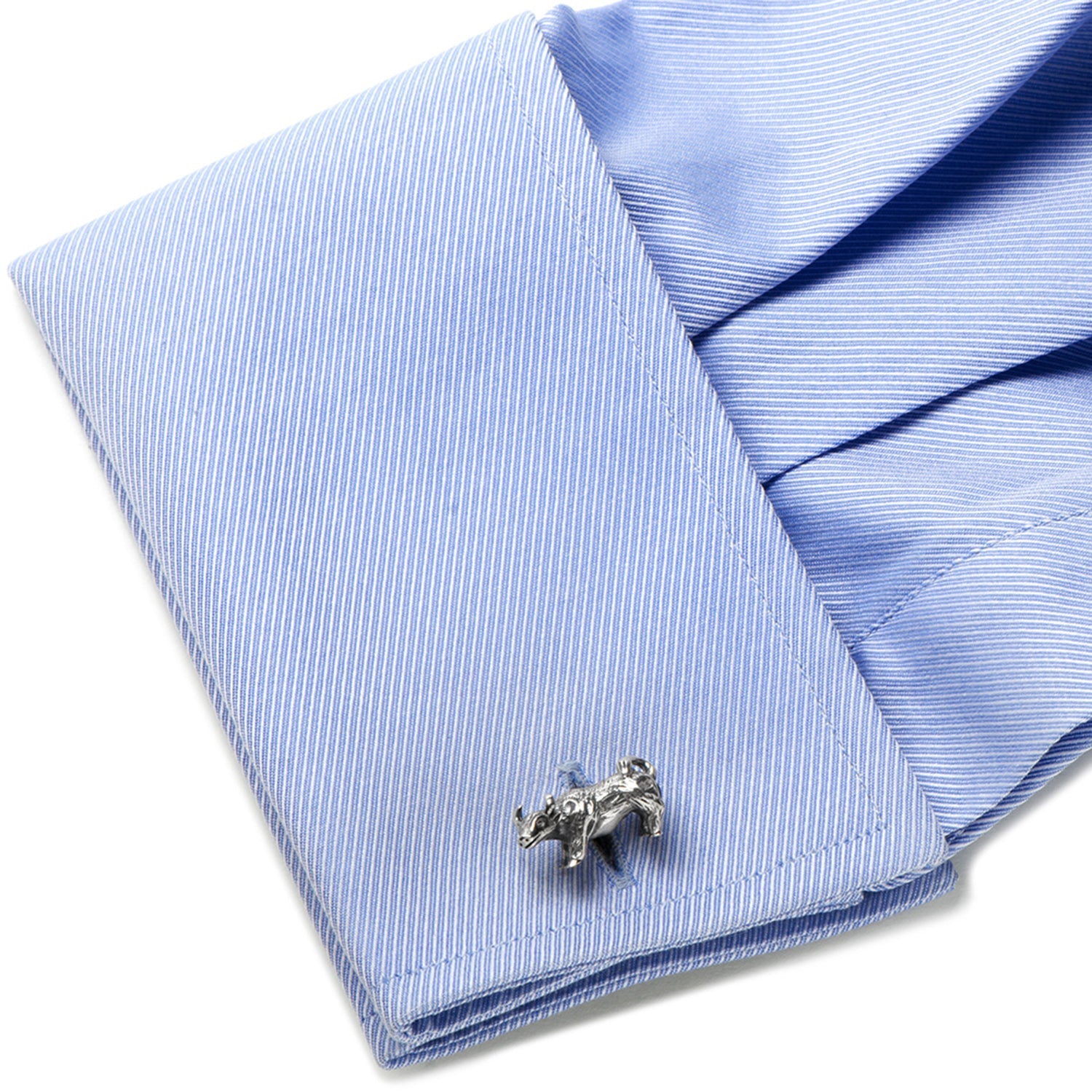 Silver bear-shaped cufflink on a blue striped shirt
