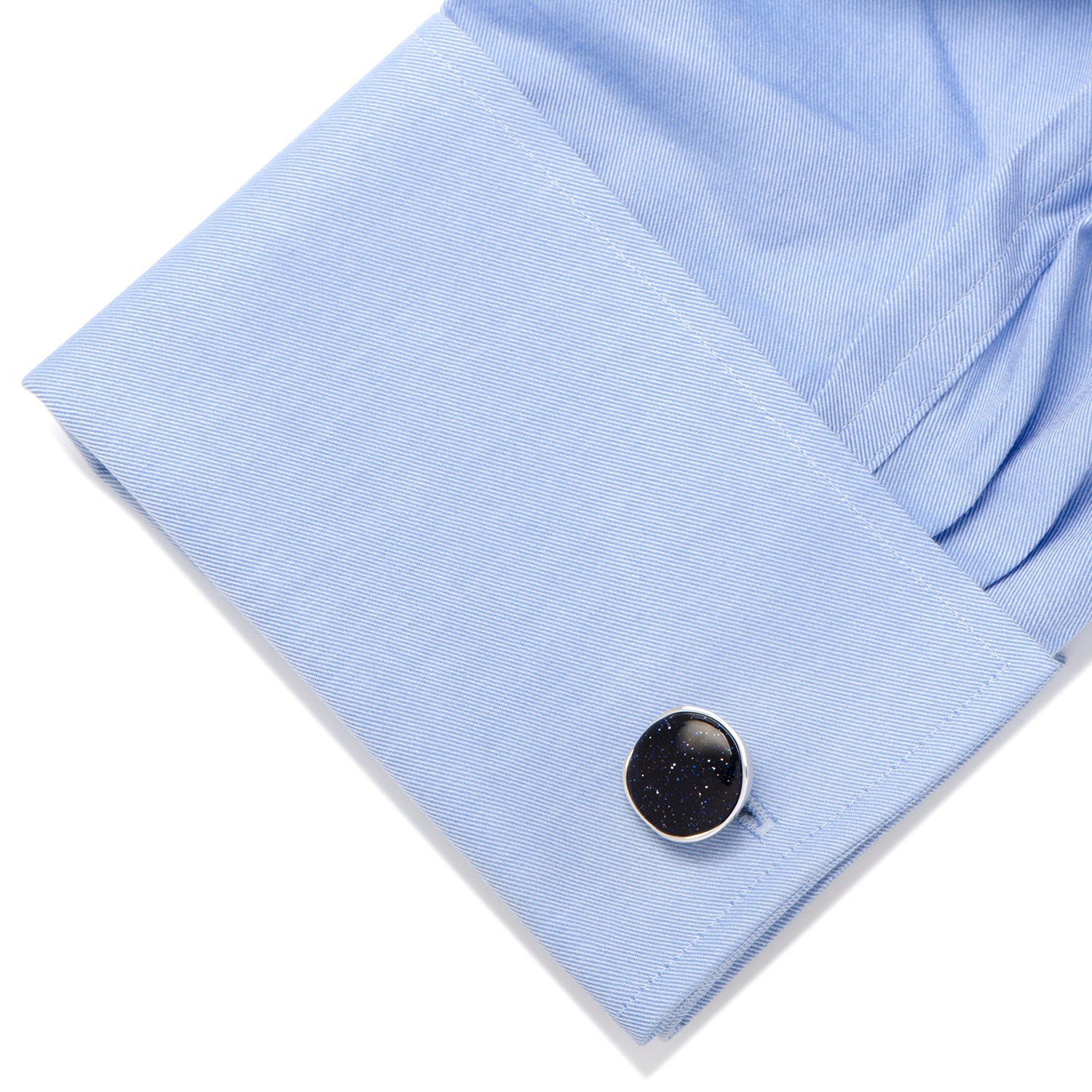 Black cufflink on a light blue shirt cuff