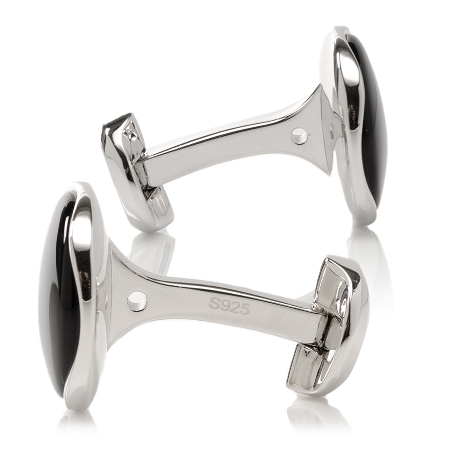 Silver cufflinks with black accents on a white background
