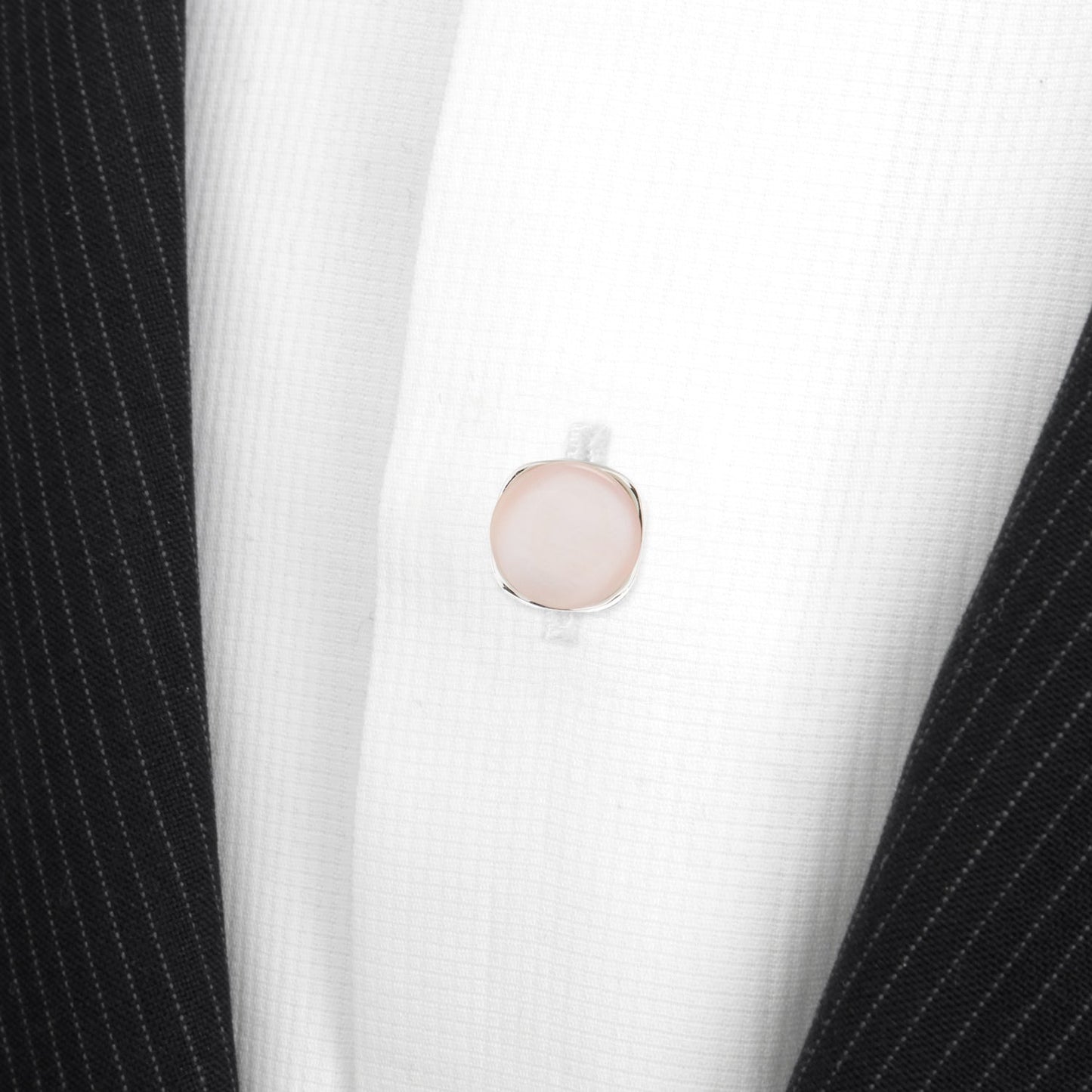 Close-up of a pink button on a black and white striped garment