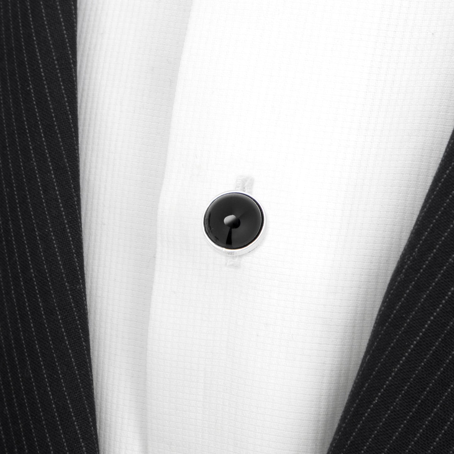 Close-up of a white shirt with a black button on a white background