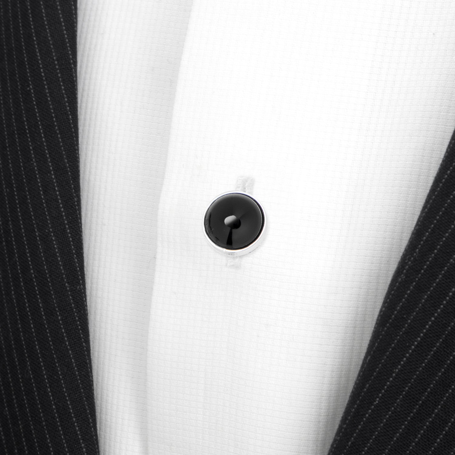 Close-up of a white shirt with a black button on a white background