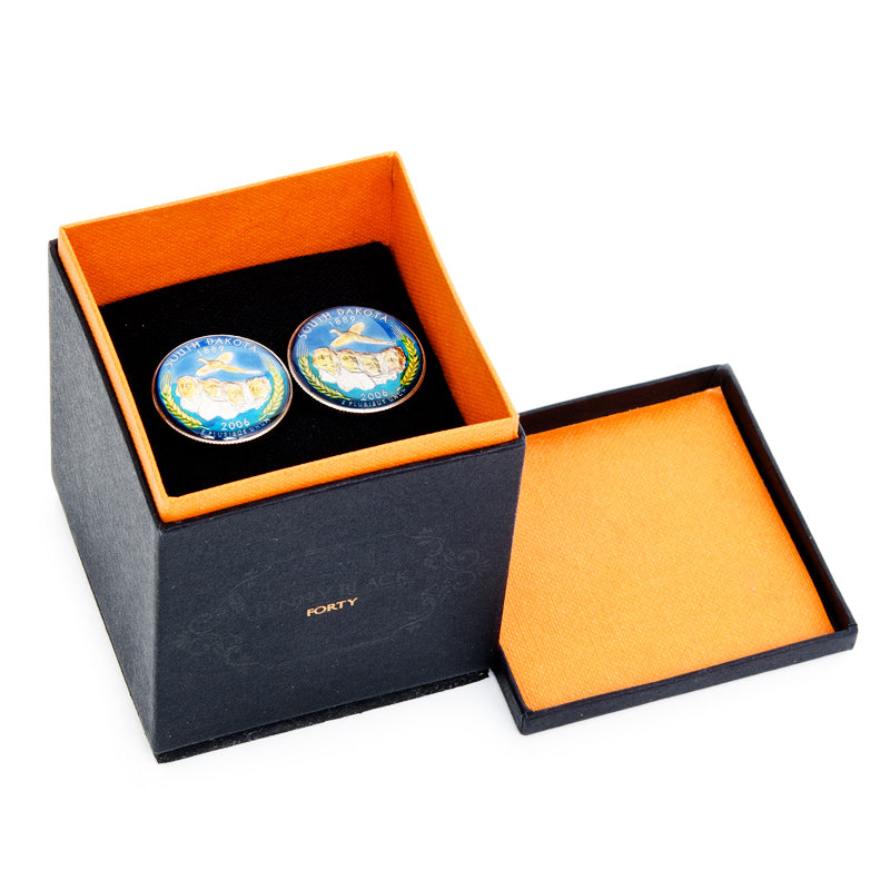 Two blue and gold circular objects in an open black and orange box.