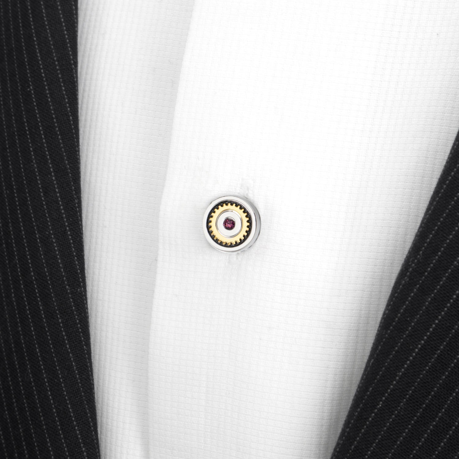 Close-up of a button on a black and white striped shirt with a detailed button design.