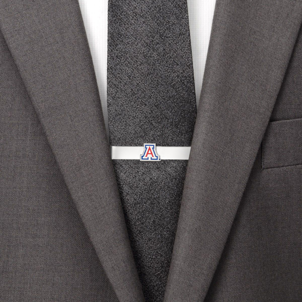 Gray suit with a black tie featuring a logo and a gray jacket lapel. Arizona Wild Cats 
