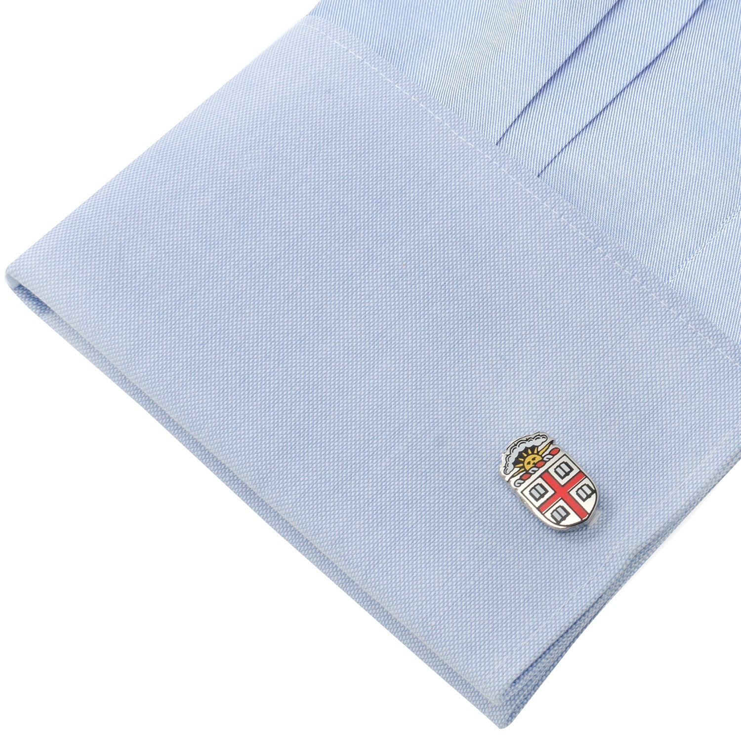 Cufflink with a coat of arms design on a light blue shirt