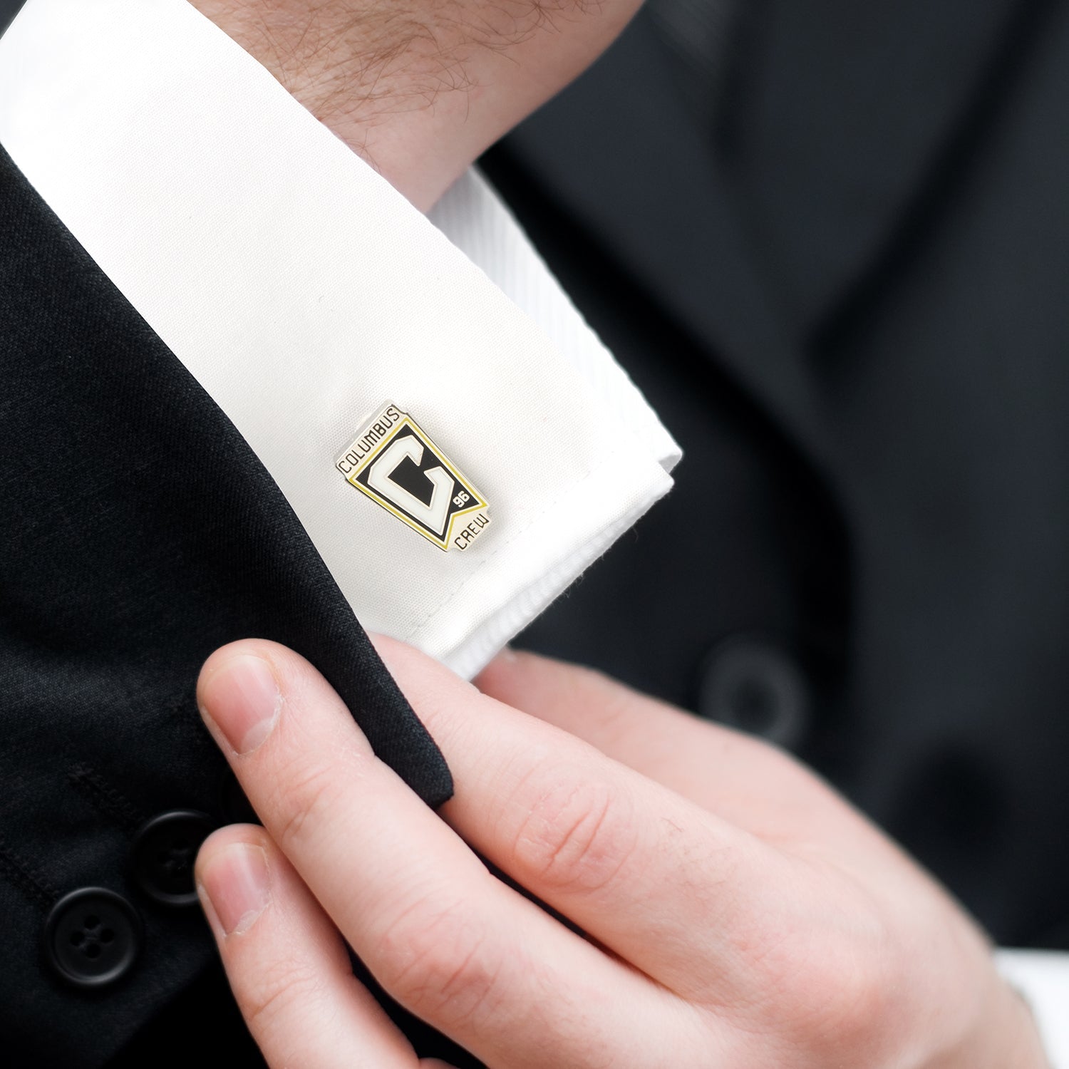 Close-up of a cufflink on a white shirt with a blurred background