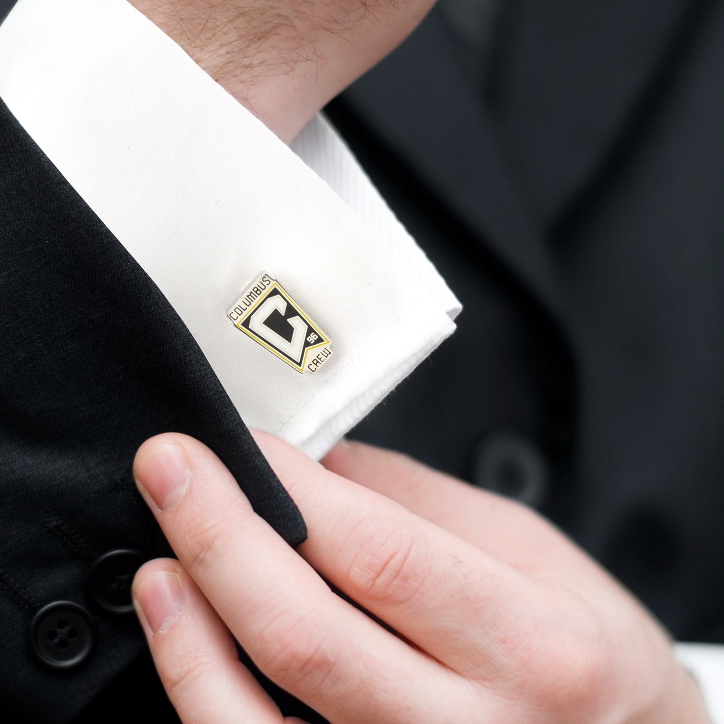 Close-up of a cufflink on a white shirt with a blurred background