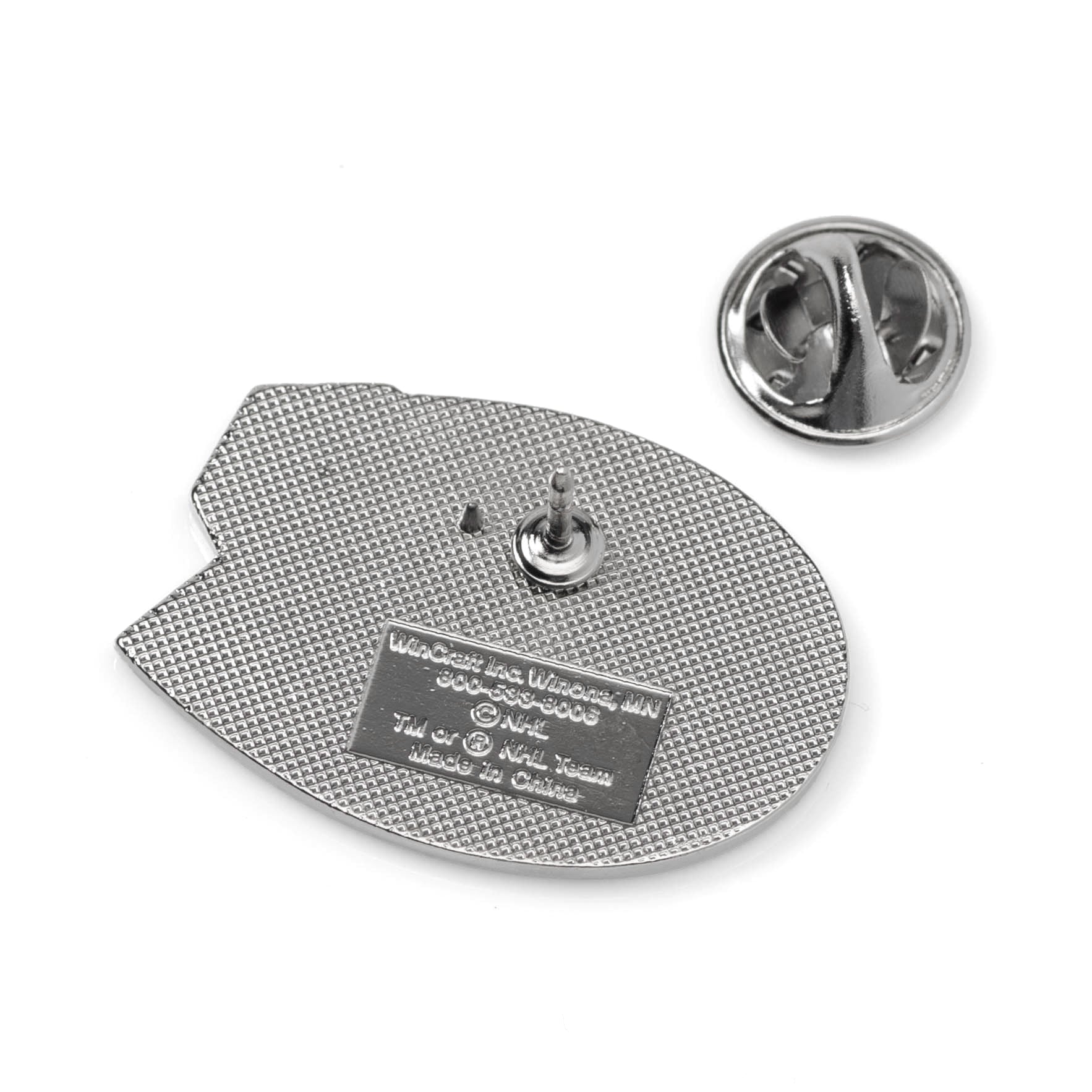 Metallic badge with a textured surface and a small label on a white background