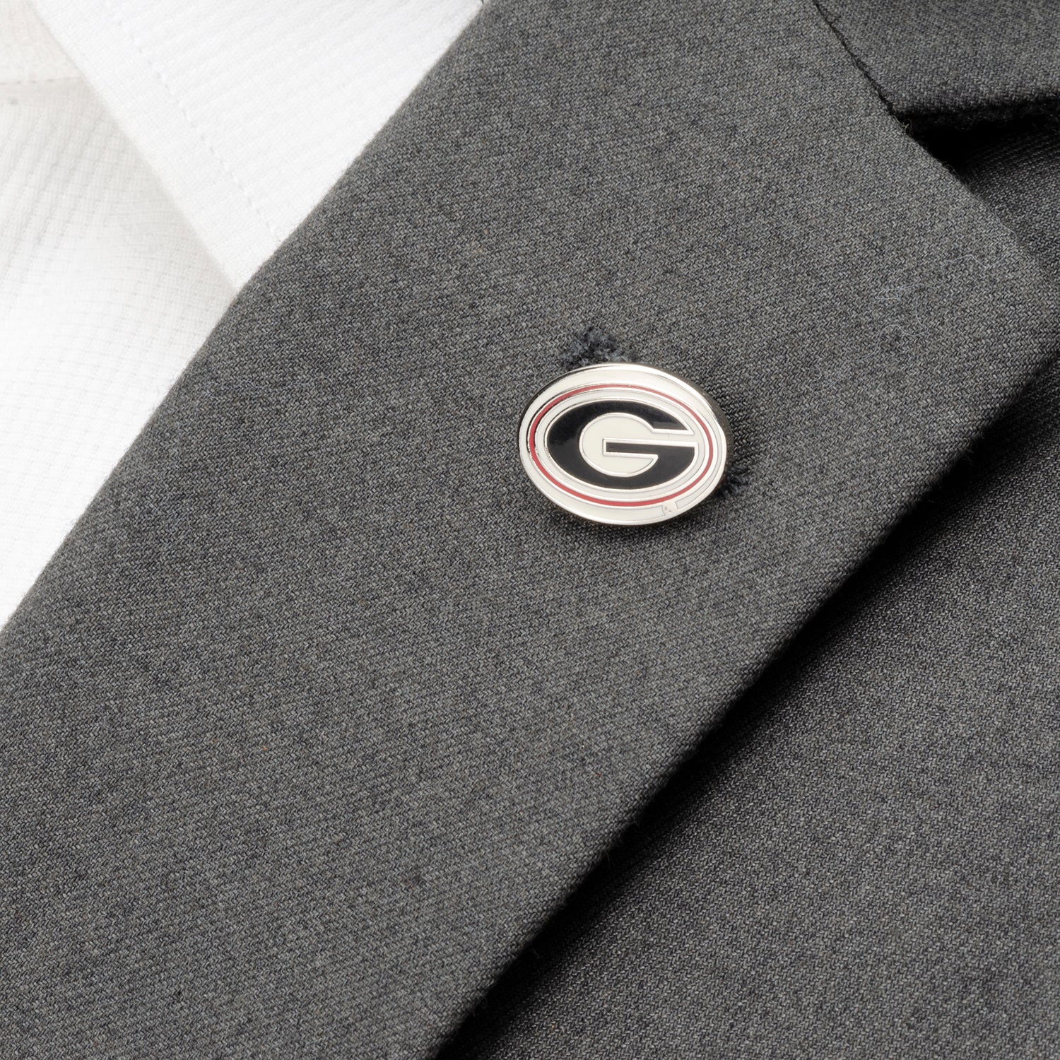Cufflink with a logo on a gray suit cuff