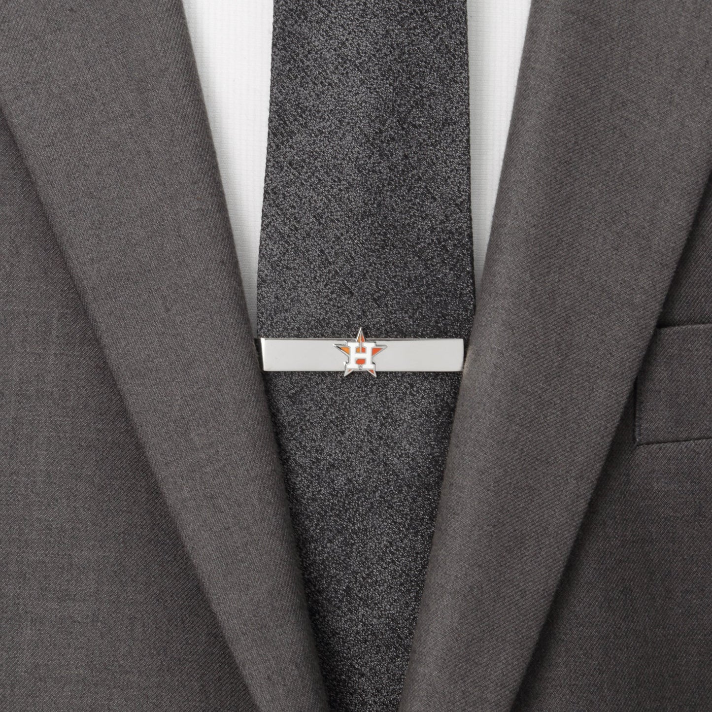 Tie clip on a gray suit jacket with a white shirt