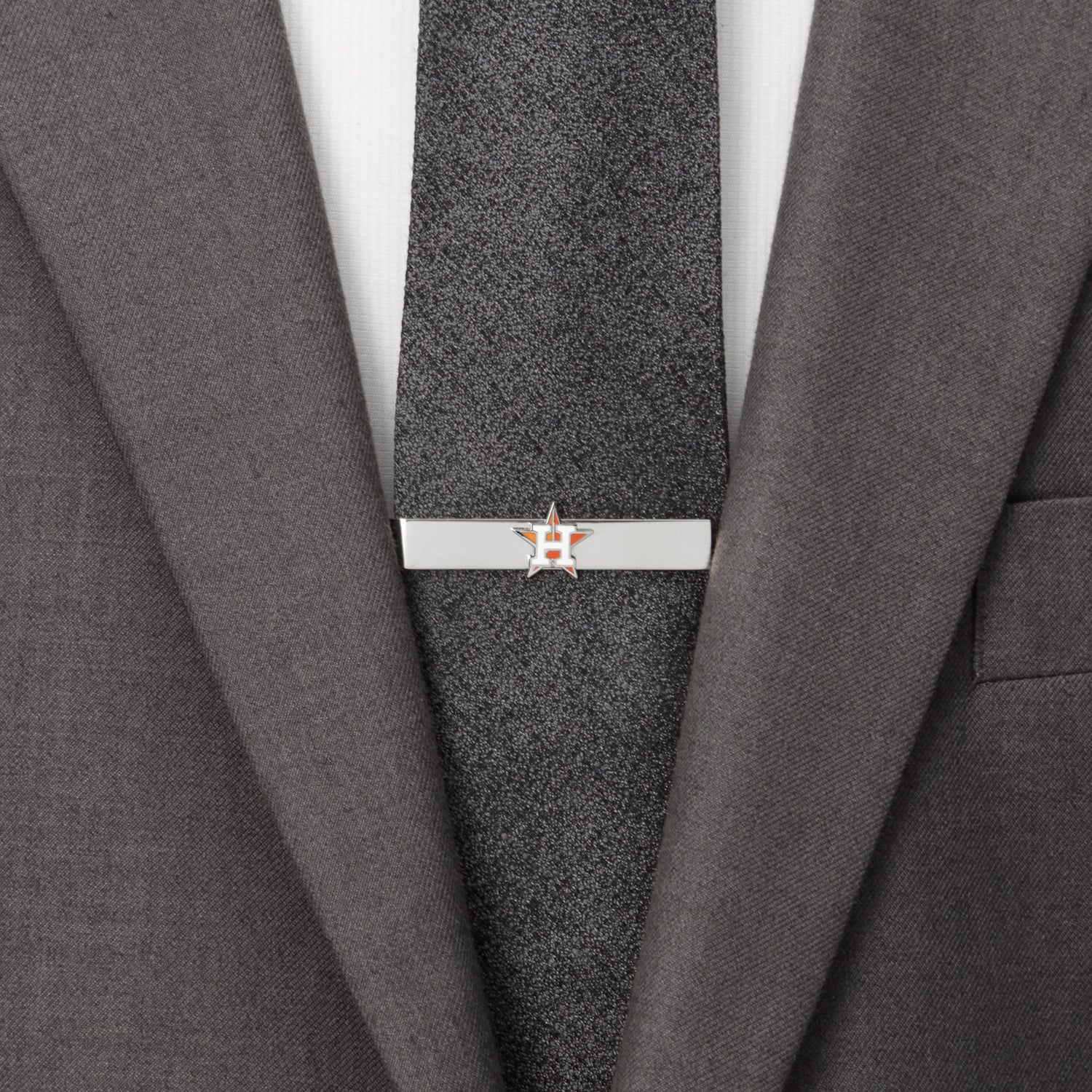 Tie clip on a gray suit jacket with a white shirt