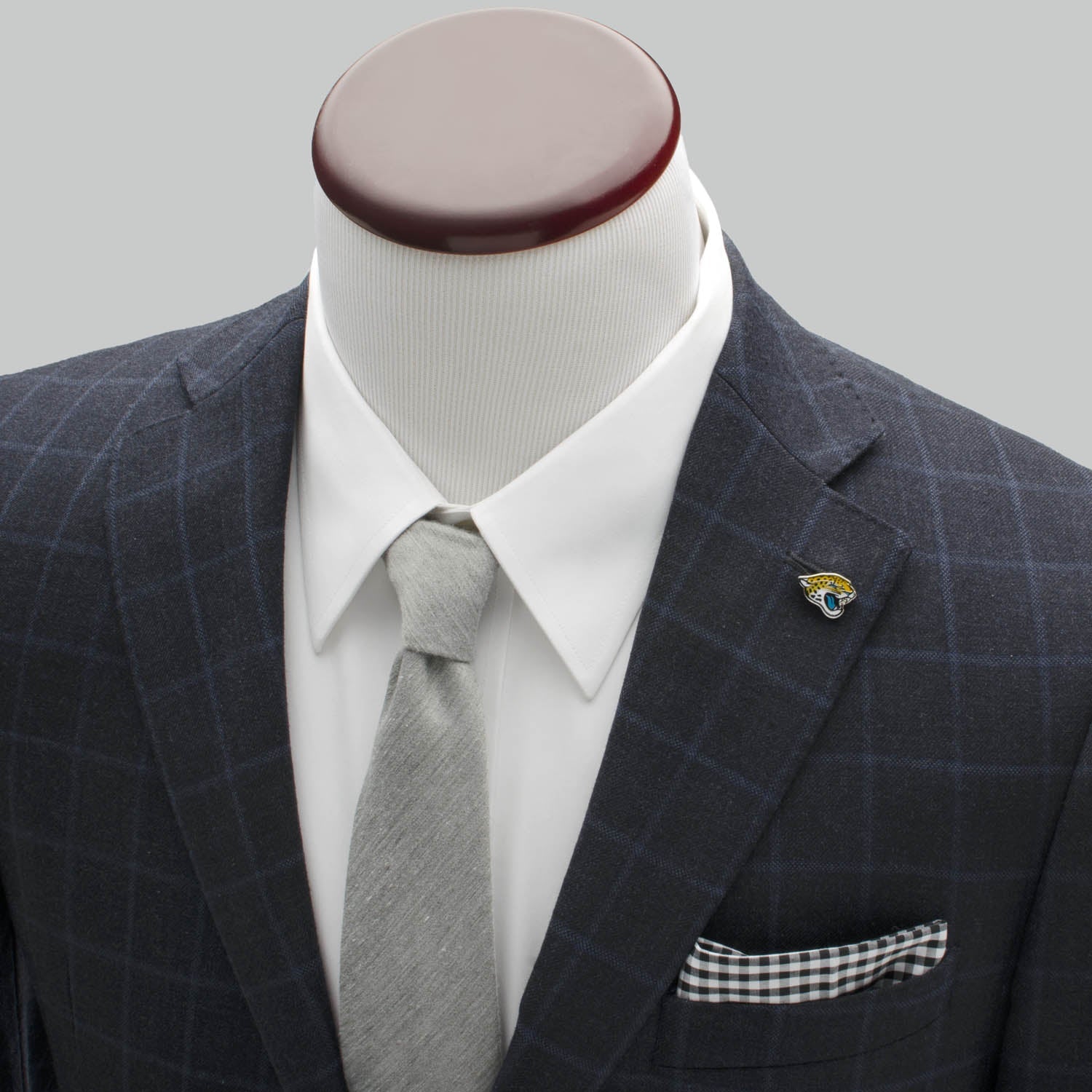 Gray checkered suit with white shirt, gray tie, and pocket square on a mannequin against a gray background.