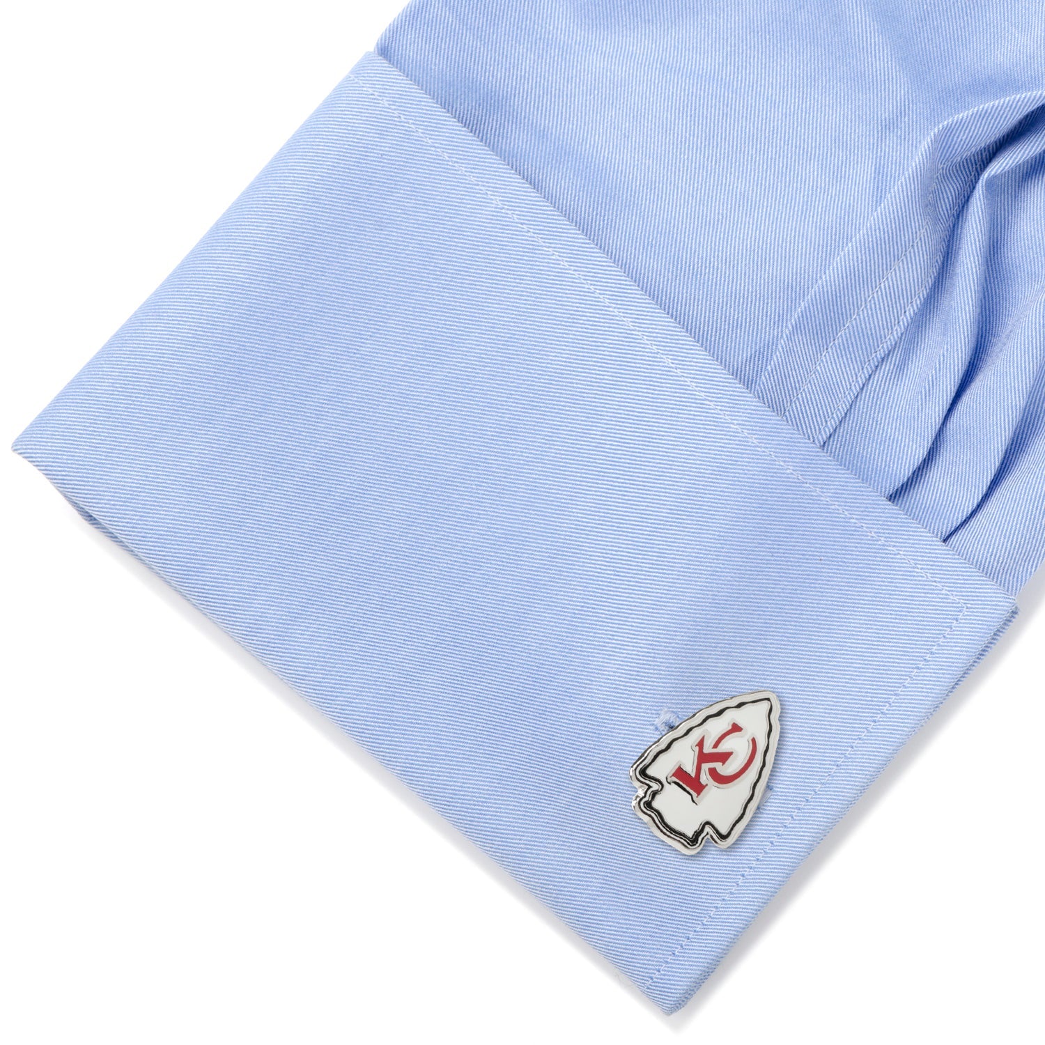 Close-up of a light blue shirt cuff with a cufflink on a white background